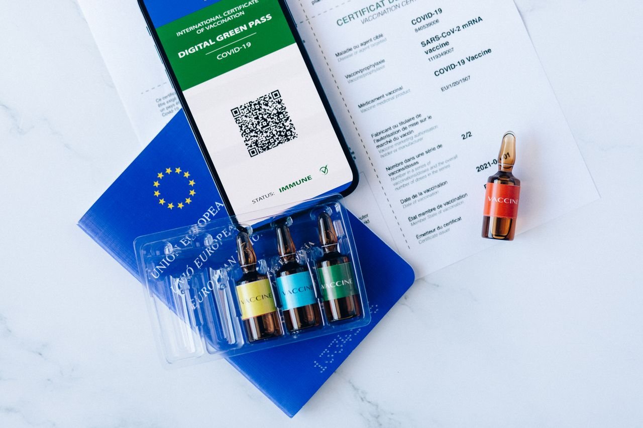Digital green pass and vaccination vials on European Union passport, symbolizing COVID-19 travel readiness.